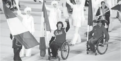  ?? LEAH HENNEL/ POSTMEDIA NEWS ?? Canada’s Josh Dueck, centre, carries the fl ag Sunday during the Sochi Paralympic­s’ closing ceremony . Canada fi nished with 16 medals .