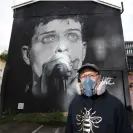  ?? ?? Street artist Akse, in front of his mural of Ian Curtis in 2020. Photograph: Kenny Brown/Alamy