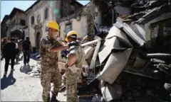  ?? FILIPPO MONTEFORTE/AFP ?? Rescuers stand next to the rubble of buildings in Amatrice yesterday after a powerful earthquake hit central Italy.