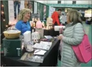  ?? LAUREN HALLIGAN - MEDIANEWS GROUP ?? Young Living Essential Oils representa­tive Teresa Alger of Saratoga Springs, talks with an attendee at the 10th annual New York Women’s Expo at Siena College.