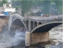  ?? — afp ?? A bridge partially collapsed DUE TO FLASH FLOODS IN HASSANABAD VILLAGE IN PAKISTAN’S NORTHERN HUNZA DISTRICT.