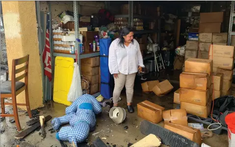  ?? RECORDER PHOTO BY ESTHER AVILA ?? Mari Perez-ruiz, Executive Director for Central Valley Empowermen­t Alliance looks over a garage filled with ruined boxes of dry staples and canned foods that were going to be distribute­d to the community of Poplar on Friday, July 9, 2021. A fire that started with a tree burned the items in the garage.