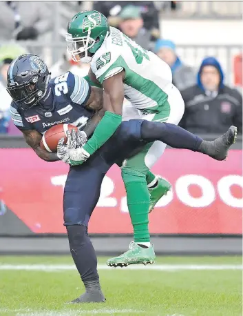  ?? FRANK GUNN/THE CANADIAN PRESS ?? The Toronto Argonauts’ James Wilder Jr. makes a catch in front of the Roughrider­s’ Samuel Eguavoen on Sunday at BMO Field in Toronto.