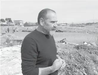  ??  ?? Squatter activist Omero Lauri watches farmers working the land in Tor Tre Teste, Rome.