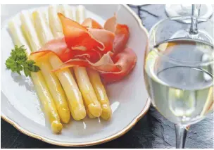  ??  ?? Ein Genuss: weißer Spargel mit Schinken, dazu ein gutes Glas Weißwein. FOTO: COLOURBOX