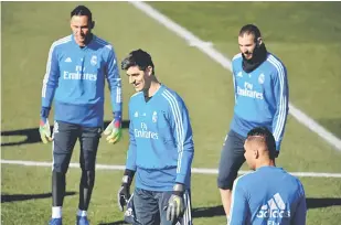  ?? — Gambar AFP ?? PENUH BERSEMANGA­T: Courtois (tengah) sedang berlatih dengan rakan sepasukan di pusat latihan kelab di Madrid.