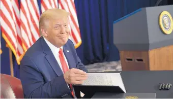  ?? SUSAN WALSH/ASSOCIATED PRESS ?? President Donald Trump smiles as he prepares to sign four executive actions during a news conference at the Trump National Golf Club in Bedminster, New Jersey, on Saturday. Trump said he expected the measures would stand up to any court challenges.