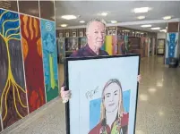  ?? NICK KOZAK FOR THE TORONTO STAR ?? Artist Jeff Sprang with one of his limited edition prints of his portrait of Olympic swimmer Penny Oleksiak, at Monarch Park Collegiate, her former high school.