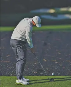  ?? AP PHOTO/DAVID J. PHILLIP ?? Rory McIlroy hits his tee shot on the 12th hole during Tuesday’s practice round for the Masters golf tournament in Augusta, Ga.