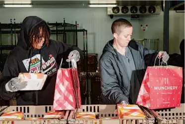  ??  ?? Bagging meals in a refrigerat­ed room