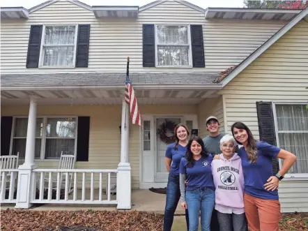  ?? PHOTOS BY SARA C. TOBIAS/NEWARK ADVOCATE ?? Cecilia Bodine, center, takes a break from packing and organizing to pose in front of her Granville home with Songbird Transition­s’ Tabi Amos, Zach Dobbelaer, Jackie Wright and Samantha Stearns. Songbird Transition­s helps clients who are downsizing their homes. Many items are donated to organizati­ons such as Fostering Further.