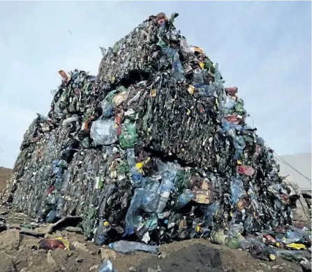  ?? THE ASSOCIATED PRESS FILES ?? Plastic trash is compacted into bales ready for further processing at the waste processing dump on the outskirts of Minsk, Belarus. A new massive study finds that production of plastic and the hard-to-breakdown synthetic waste is soaring in huge...