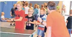  ?? FOTOS (2) : KÜPPERS ?? Mit Verve gehen die Grundschül­er beim Tischtenni­s zu Werke. Die Sportlehre­r Oliver Fimmers und Dennis Homann geben Tipps.