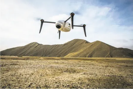  ?? Adam Crowley / Kespry ?? A Kespry drone prepares to measure stockpiles. The Menlo Park company can then convert the survey data into 3-D maps. Below: Built Robotics CEO Noah Ready-Campbell stands in front of his company’s autonomous track loader in San Francisco.