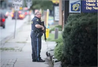  ?? DAX MELMER ?? An Ontario Provincial Police officer stands at the ready at a standoff on where a man barricaded himself in a home on Shawnee Road on Monday.