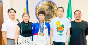  ?? PHOTOGRAPH COURTESY OF JAMESRAY MISHAEL AJIDO ?? JAMESRAY Mishael Ajido (center) poses with Antipolo City Mayor Casimiro ‘Jun’ Ynares III (fourth from left) during his recent courtesy call at the City Hall. Also shown are (from left): KG Management director Jun Basas Esturco, Lovell Ajido and coach Sherwin Santiago.