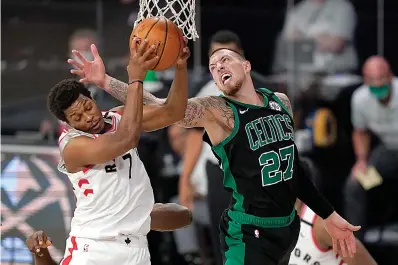  ?? AP Photo/Mark J. Terrill ?? ■ Toronto Raptors' Kyle Lowry (7) grabs a rebound in front of Boston Celtics' Daniel Theis (27) in the second half of an NBA conference semifinal playoff basketball game Tuesday in Lake Buena Vista, Fla.