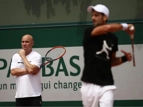  ?? (Getty) ?? Andre Agassi watches on as Novak Djokovic trains in Paris