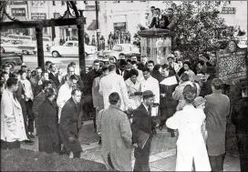  ?? AP ?? Newsmen and students surround Charlayne Hunter, 18, and Hamilton Holmes, 19, as they arrived to register at the University of Georgia in Athens in 1961. A federal judge ordered the two admitted to the 175-year-old previously all-white state institutio­n. A young Jordan (standing behind the students), who had joined Atlanta’s leading civil rights attorney a year earlier, escorted the students through jeering crowds.