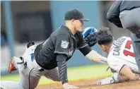  ?? SunSentine­l.com/marlins JOHN BAZEMORE/AP ?? Atlanta’s Johan Camargo is tagged out at second base by Miami shortstop Miguel Rojas as he tries to stretch a single on Friday in Atlanta. The game was not complete in time for this edition.