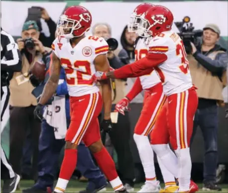  ?? THE ASSOCIATED PRESS ?? Teammates of Kansas City Chiefs’ Marcus Peters, left, try to prevent him from leaving the field after a penalty during the second half. Peters tossed the official’s flag into the stands and then walked out thinking he had been ejected.