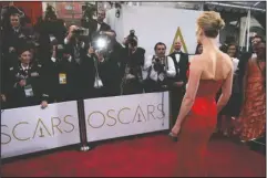  ?? The Associated Press ?? GLAMOUR: Actress Rosamund Pike arrived at the Oscars on Feb. 22, 2015, in Los Angeles. There are two paths on the Oscars red carpet: one for famous people, and one for everyone else. Stanchions and velvet ropes separate the recognizab­le from the not....