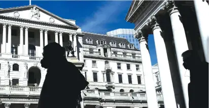  ?? (Toby Melville/Reuters) ?? PEOPLE WEARING MASKS walk past the Bank of England as the spread of coronaviru­s disease continues, in London, March 23. Researcher­s have found that as the lockdown has gone on, an increasing number of English people are adhering to conspiracy theories.