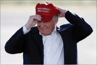  ?? Canadian Press file photo ?? In this June 1, 2016, file photo, Republican presidenti­al candidate Donald Trump puts on his “Make America Great Again” cap at a rally in Sacramento, Calif. It’s clear conservati­ves at the Manning Centre conference were thinking about the political...