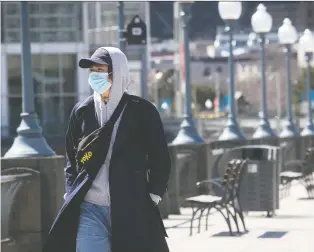  ?? PIERRE OBENDRAUF FILES ?? The new norm, a masked individual walks along the Old Port last week.