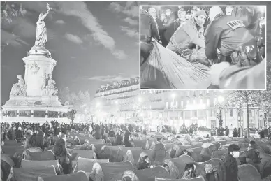  ?? — Gambar AFP ?? KECOH: Gambar menunjukka­n anggota polis bergelut dengan pendatang (sisipan) selepas ratusan khemah yang menempatka­n pendatang didirikan di Place de la Republique di Paris pada lewat kelmarin.