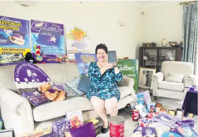  ??  ?? Gill Cocks in her home in Winchcombe, surrounded by Cadbury memorabili­a