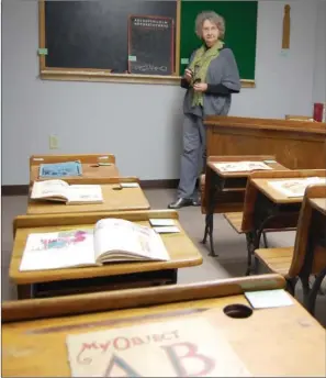  ?? WAYNE BRYAN/TRI-LAKES EDITION ?? Ferrell Ford, who created the black-history exhibition at the Arkadelphi­a Arts Center, stands next to a teacher’s desk taken from the old Peake Elementary School, in a display reflecting school classrooms in the 1930s and ’40s. The exhibition will run...