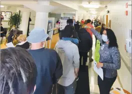  ?? PHOTOS BY JETHRO BOWERS — THE MENDOCINO VOICE VIA AP ?? HeAlth cAre worker directs people lined up in the Adventist HeAlth UkiAh VAlley MedicAl Center, MondAy, in UkiAh to get the ModernA COVID-19 vAccinAtio­n during An emergency vAccine drive. A power fAilure for the freezer holding the county’s rAtion of the ModernA vAccines forced the emergency distriButi­on of 850 doses of thAt vAccine.