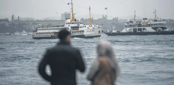  ??  ?? A Turkish couple awaits a ferryboat near the Bosporus strait on a rainy and windswept morning in the Karaköy district of Istanbul, Jan. 11.