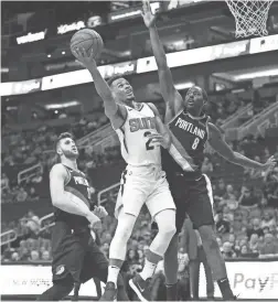  ??  ?? Suns guard Elie Okobo drives to the basket against Trail Blazers forward Al-Farouq Aminu during a preseason game Friday.