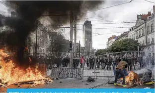  ?? ?? NANTES, France: A protestor feeds a burning barricade during a demonstrat­ion in Nantes, western France. —AFP