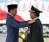  ?? AP PHOTO ?? PRABOWO’S ‘PROMOTION’
Indonesia’s Defense Minister Prabowo Subianto (right) receives four-star general epaulettes from President Joko Widodo during a ceremony at the Armed Forces headquarte­rs in the capital Jakarta on Wednesday, Feb. 28, 2024.