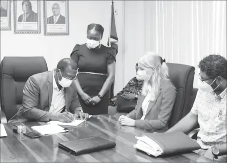  ?? (DPI Photo) ?? Director-General of the Maritime Administra­tion Department, Stephen Thomas signing the contract as Koole Contractor­s’ representa­tive, Janneke Kuijper (second from right) and Ministry of Public Works Permanent Secretary, Vladim Persaud (right) look on