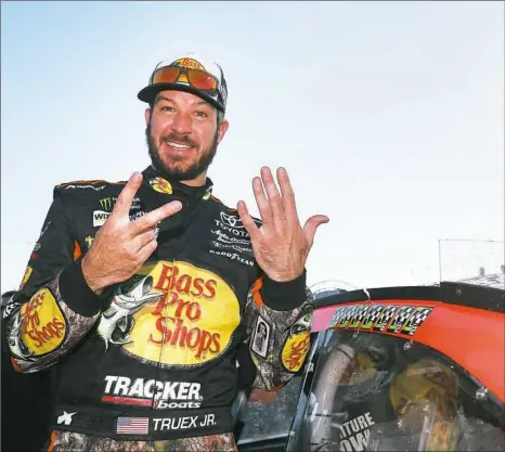  ?? Sarah Crabill/Getty Images ?? Martin Truex Jr. extended his points lead with a win in the Hollywood Casino 400 Sunday at Kansas Speedway. Truex is holding up seven fingers, one for each of his wins this season.