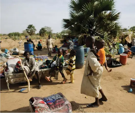  ?? ?? ► Un niño sudanés lleva a su hermano y espera ser trasladado a un campamento de refugiados, en la frontera de Sudán y Chad.