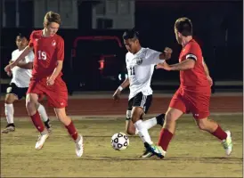  ?? TIM GODBEE / For the Calhoun Times ?? Calhoun’s Daniel Isep (11) works the ball up the field between two LFO defenders during Thursday’s game.