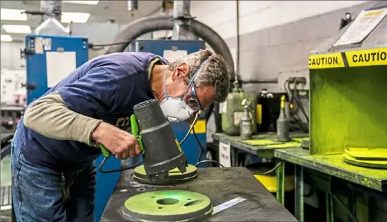  ?? Michael M. Santiago/Post-Gazette ?? Mike Wampler, a supervisor, checks for cracks on a freshly shaped tungsten carbine product at General Carbide Corporatio­n in Greensburg on Dec. 19. The company manufactur­es tungsten carbide tooling and tool steels and has been around for a half-century.