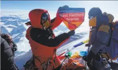  ?? Lhakpa Sherpa via Associated Press 2017 ?? Lhakpa Sherpa holds a flag from West Hartford, Conn., on top of Mount Everest last year. She plans to climb it again this month.