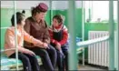  ?? ?? In the dormitory, two students chat with a teacher who oversees their daily life.