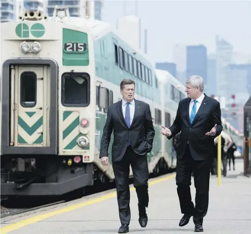  ?? Da rren Calabrese / The Cana dian Press ?? Mayor John Tory, left, and Prime Minister Stephen Harper walk along the platform of a GO station Thursday. Harper announced that the federal government will pony up $2.6 billion for Tory’s SmartTrack transit plan.