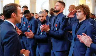  ??  ?? Bleu-blanc-rouge. Remise de la Légion d’honneur aux champions du monde de football au palais de l’Élysée, le 4 juin 2019. La facétie martiale d’Antoine Griezmann fait sourire le président.