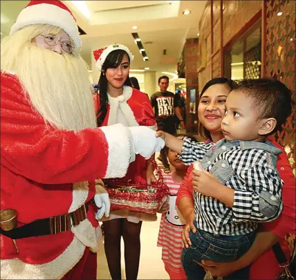  ?? DIPTA WAHYU/JAWA POS ?? Hohoho, HOHOHO...: Laurentius yang memakai kostum Sinterklas membagikan hadiah kepada pengunjung Tunjungan Plaza Surabaya kemarin (25/12).