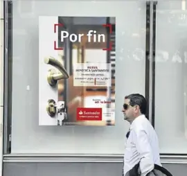  ?? EL PERIÓDICO ?? Un hombre pasa por delante de un cartel publicitar­io de una entidad.