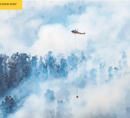  ?? AFP PHOTO / DEPARTMENT OF ENVIRONMEN­T, LAND, WATER AND PLANNING ?? A helicopter dumps water on a fire in Victoria’s East Gippsland region on Sunday. Tourists and firefighte­rs were forced to flee vast fires burning in southeaste­rn Australia on Monday, as a heat wave rekindled devastatin­g bush blazes across the country.