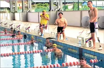  ??  ?? Rapelson (standing right) and his swim mates during training at the Youth and Sports Complex.